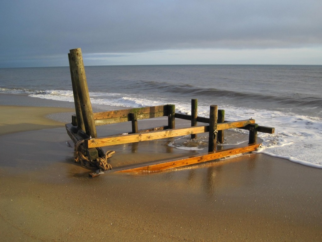 Wooden structure on beach at sunset