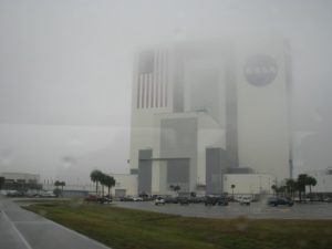 NASA administration building out a rain-streaked bus window.