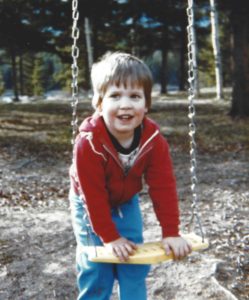 Young boy in candid pose with swing.