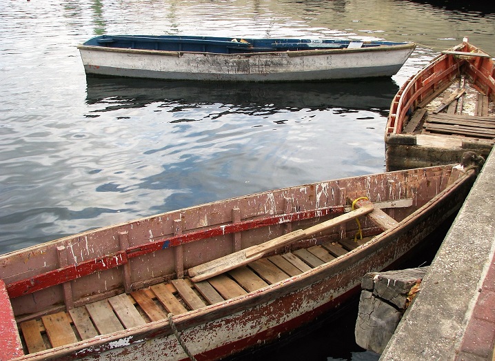 Three weathered seagoing rwoboats in Curacao harbour.