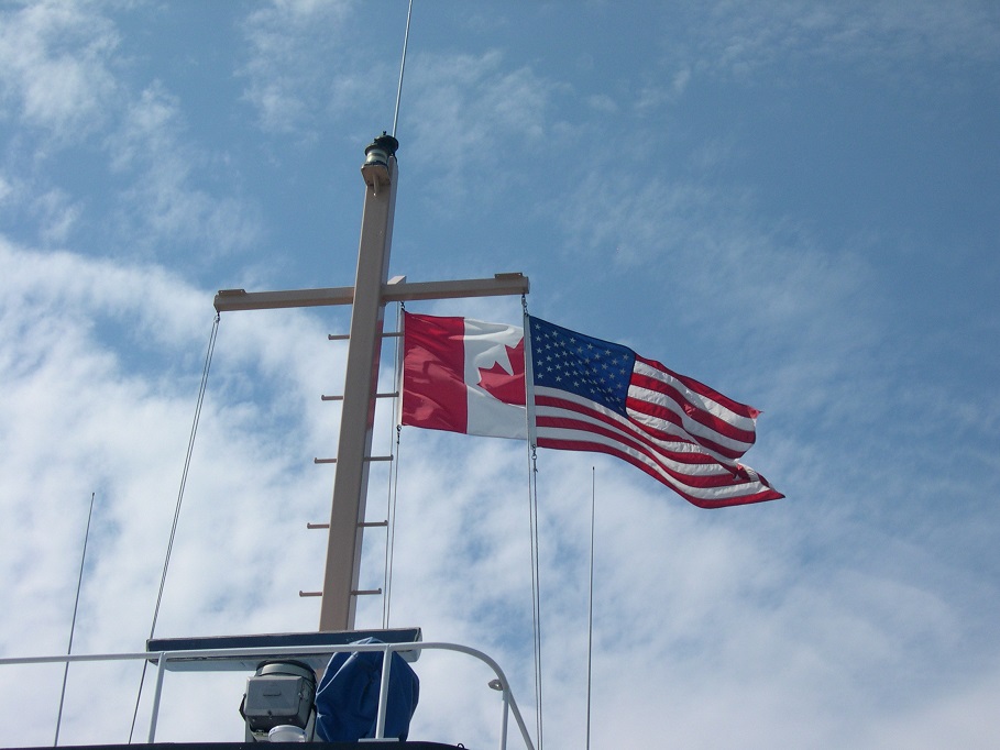 Canadian and American flags on ferry superstructure.