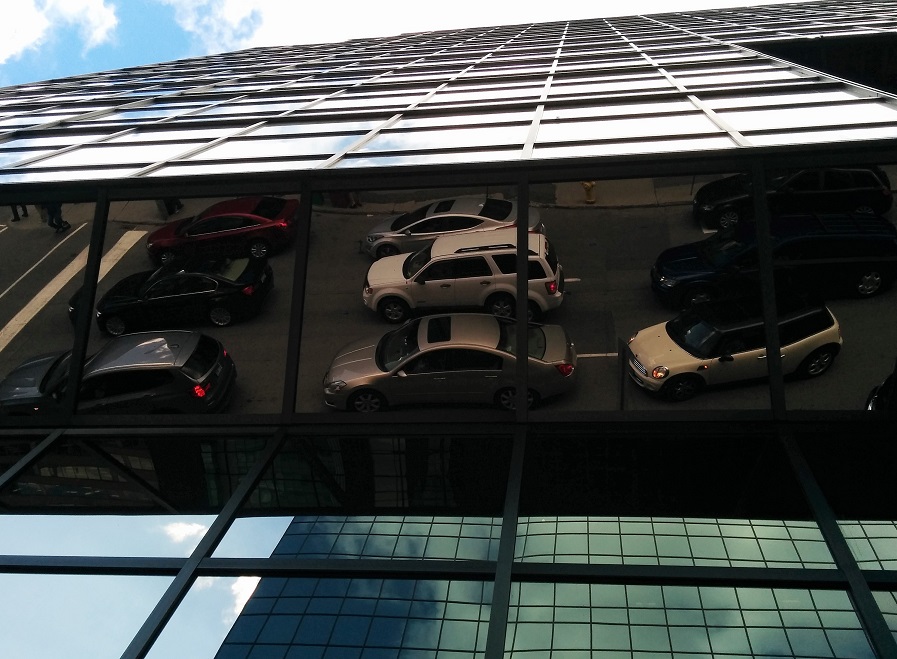 Reflection of cars in overhead, angled mirror tiles