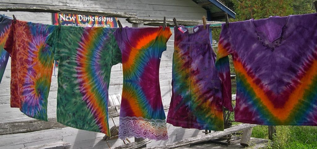 Tie-dyed clothes hanging on a clothesline.