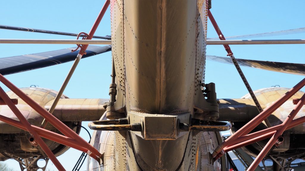 View of complex strut structure of helicopter from underneatn the tail.