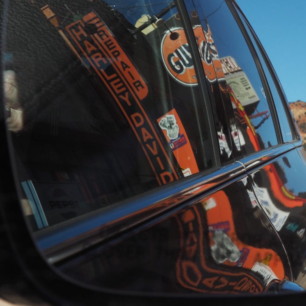 Street signs distorted in rear-view car mirrors.
