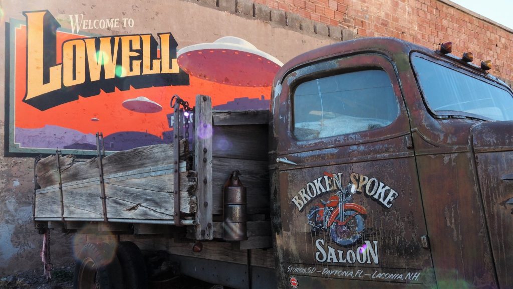 Broken-down old truck in front of UFO mural