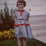 Five-year-old girl in 1957; gingham dress and saddle oxfords.