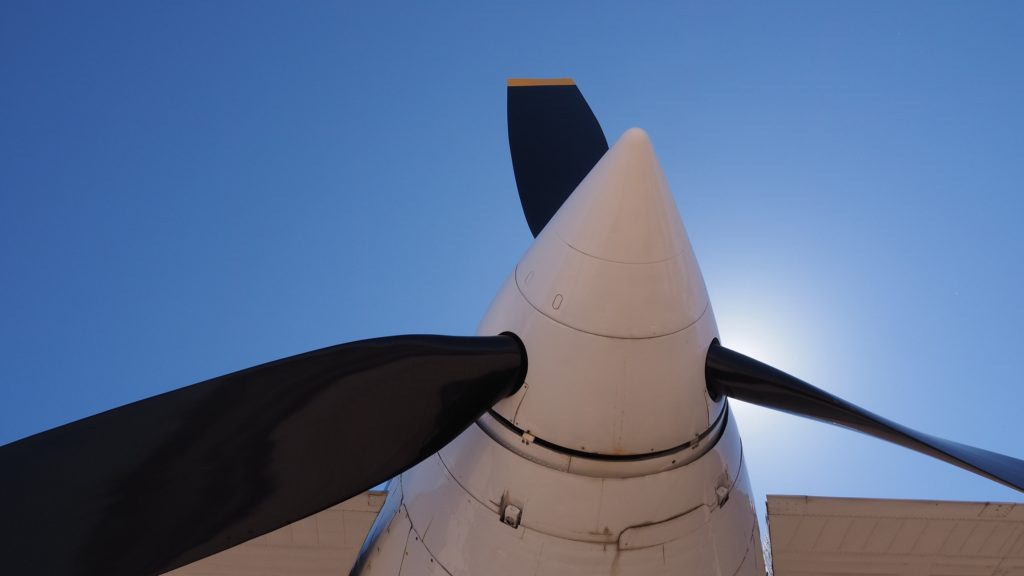 Three propellers on an airplane, backlit with sun.