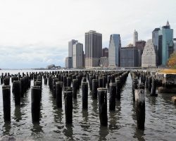 Posts in East River in foreground; Manhattan in background