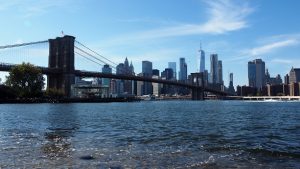 East River, with Manhattan skyline showing through Brooklyn Bridge in background.