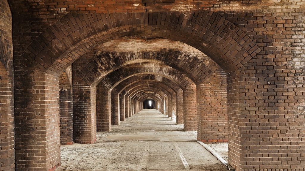 Long hallway of brick arches on gun deck of fort.