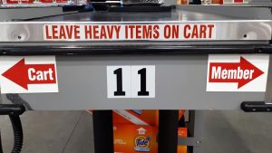 Sign at Costco checkout indicating where the cart goes.