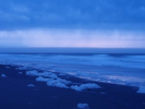 Low tide in the early morning, with foam at edge of water