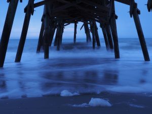 View of horizon from underneath wooden pier