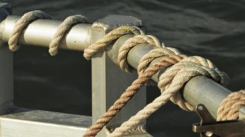 Tan and beige ropes tied off on boat railing