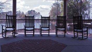 5 rocking chairs overlooking a river