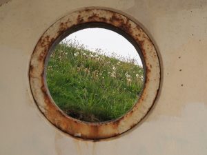 View through porthole in concrete beach shelter