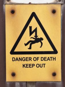 Graphic sign showing guy killed by electricity