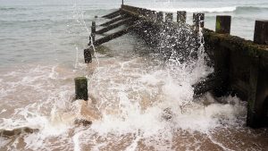 Incoming tide splashing against breakwater