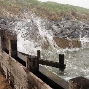 Incoming tide splashing against breakwater