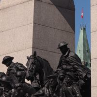 WWI soldiers on cenotaph, backed by Parliament Hill