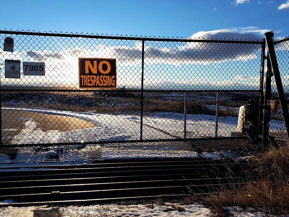 No Trespassing sign in foreground, with Prairie in background