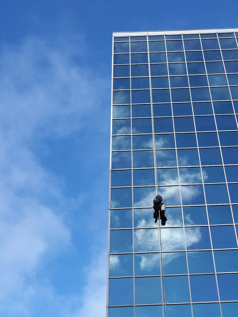 Window washer/repairer hanging against high-rise