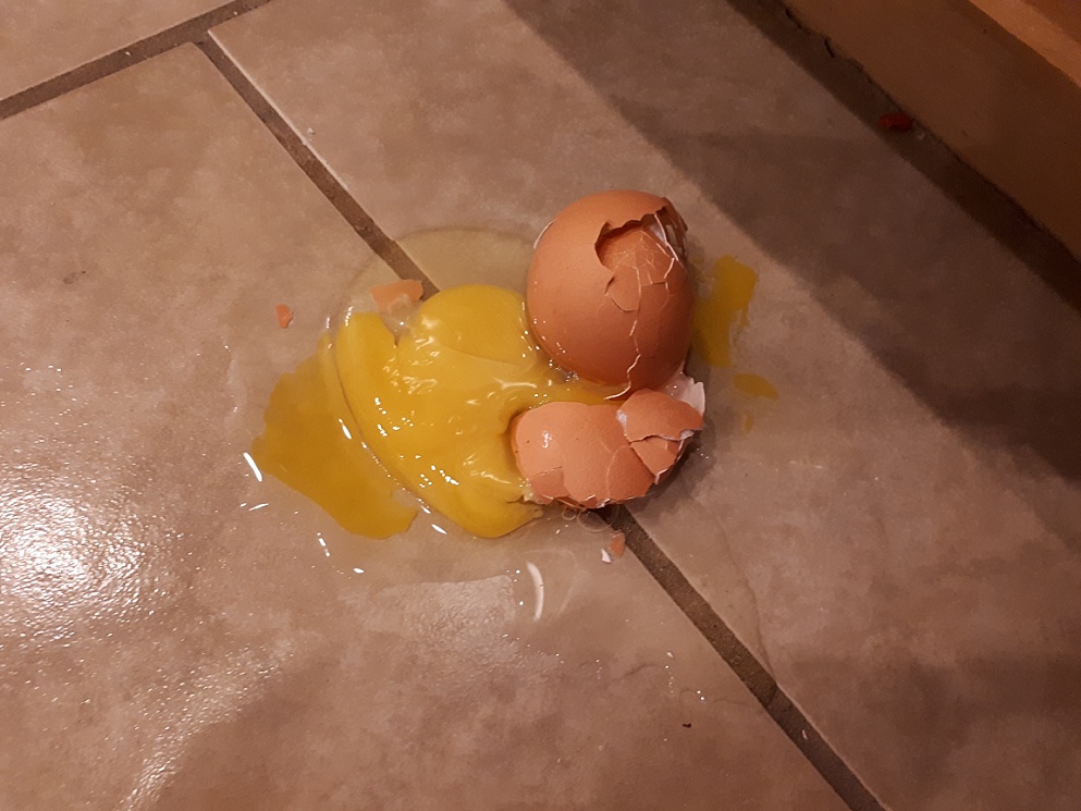 Egg smashed on ceramic-tile floor