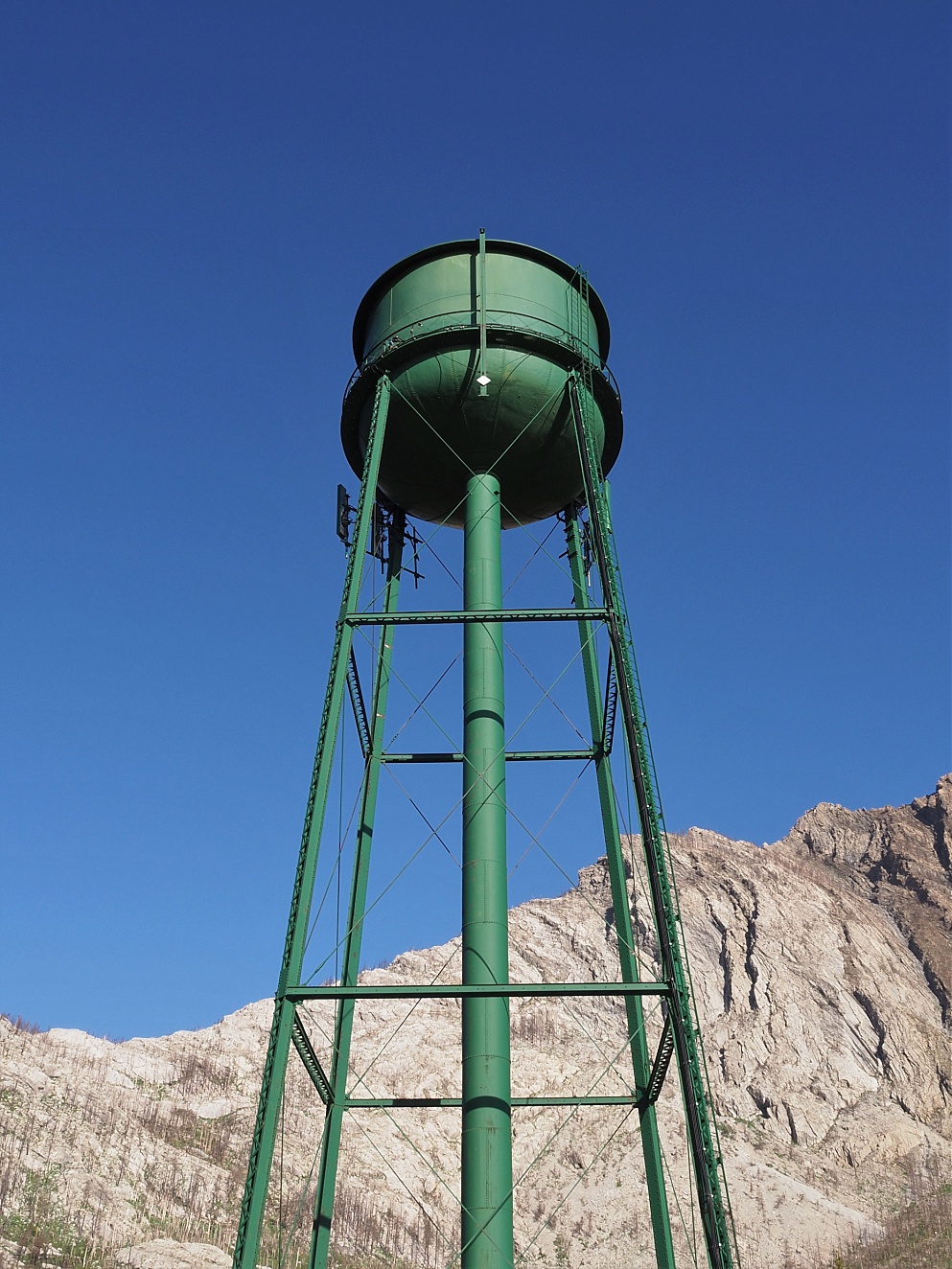 Water tower towering over mountain in background