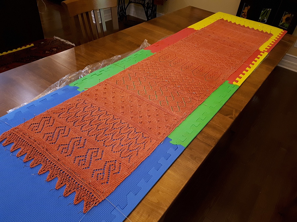 Lace shawl stretched out on dining room table for blocking